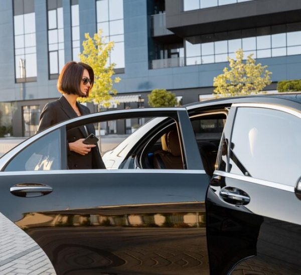 elegant-business-woman-gets-luxury-black-car-near-office-building-hotel-concept-business-transportation-travel_506452-21706
